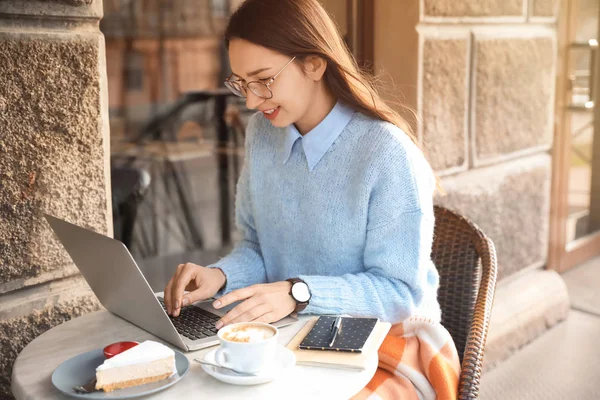 Young woman with laptop in outdoor cafe — 스톡 사진