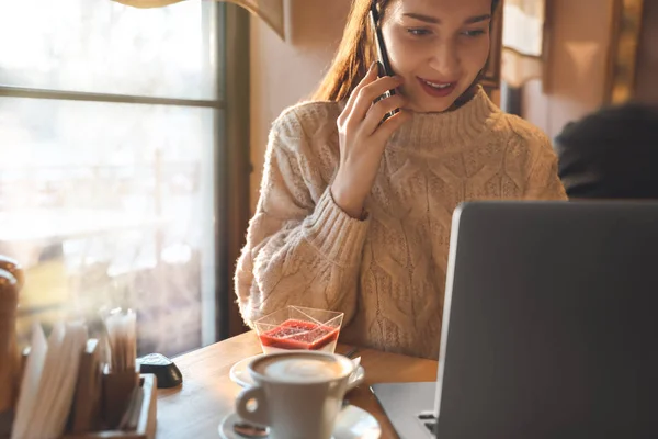 Mulher com laptop conversando por telefone no café — Fotografia de Stock