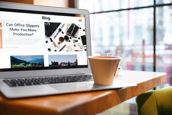 Laptop with cup of coffee on table in cafe — 스톡 사진