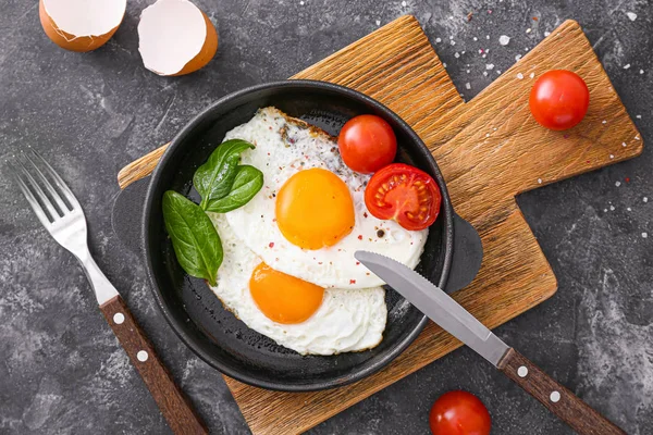 Frying pan with tasty eggs on table — Stock Photo, Image