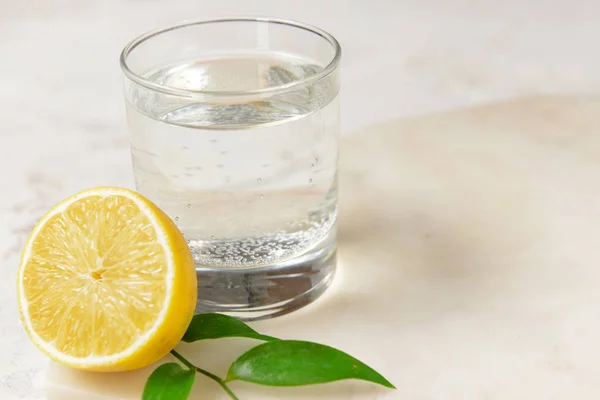 Vaso de agua limpia y limón sobre fondo claro — Foto de Stock