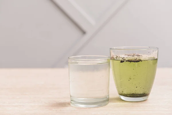 Glazen met schoon en vuil water op tafel — Stockfoto