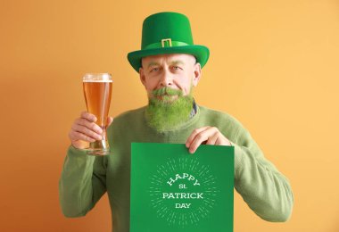Elinde bir bardak bira ve posterle komik olgun bir adam. Renkli arka planda Aziz Patrick Günü 'n kutlu olsun.