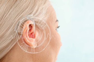 Mature woman with hearing aid on light background, closeup clipart