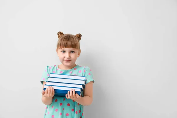 Hafif arka plan kitapları olan sevimli küçük bir kız. — Stok fotoğraf