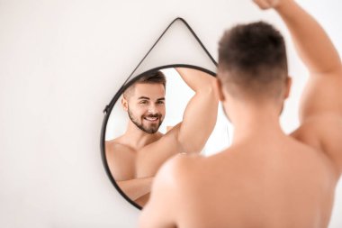 Deodorant banyoda kullanarak yakışıklı genç