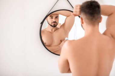 Deodorant banyoda kullanarak yakışıklı genç