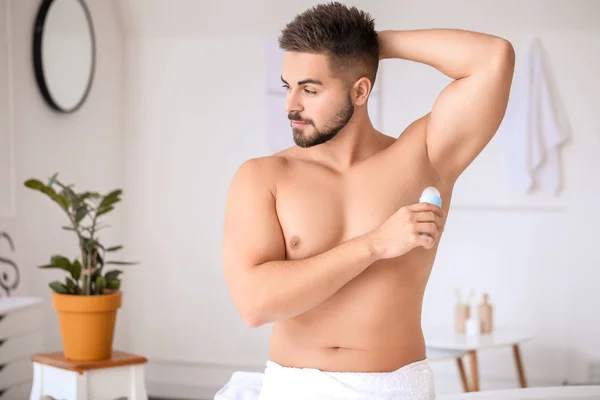 Joven guapo usando desodorante en el baño — Foto de Stock