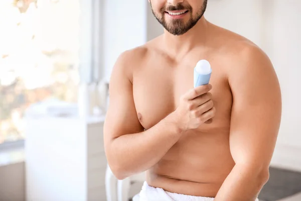 Bello giovanotto con deodorante in bagno — Foto Stock