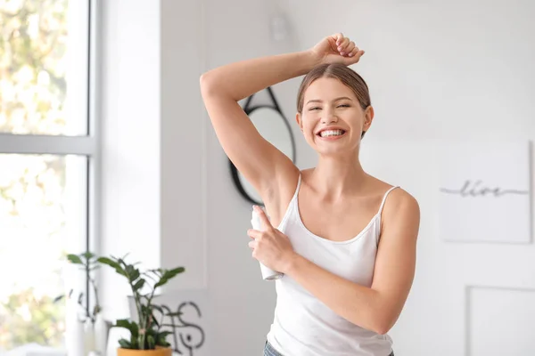 Mulher bonita usando desodorizante em casa — Fotografia de Stock