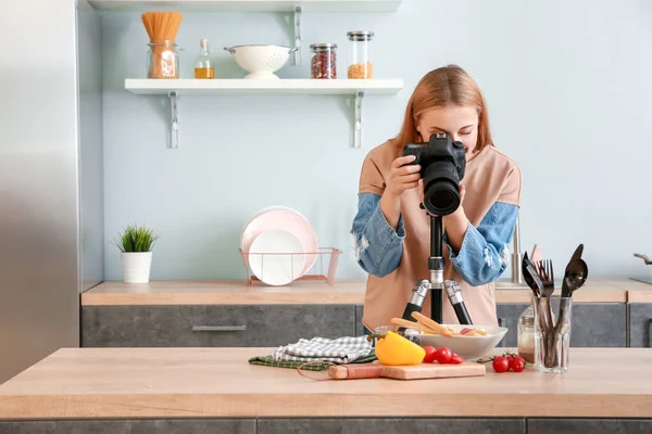 Genç fotoğrafçı mutfakta sebze salatası fotoğrafı çekiyor. — Stok fotoğraf