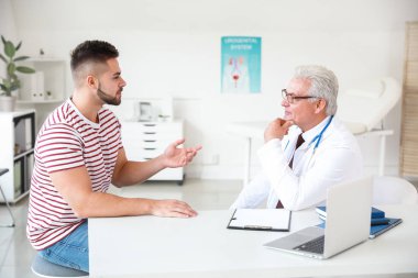 Genç adam ürolojisti klinikte ziyaret ediyor.