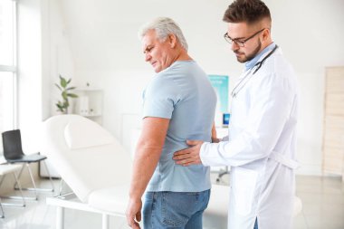 Ürolog klinikte olgun bir hastayı muayene ediyor.