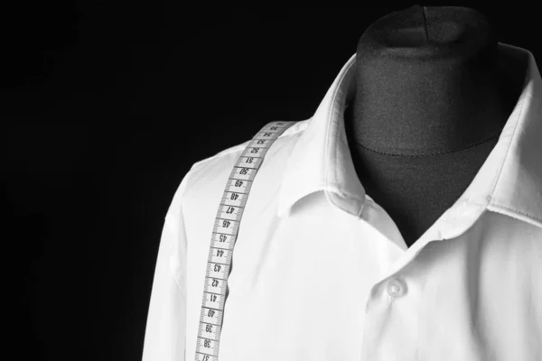 Mannequin with custom tailored shirt and measuring tape on dark background, closeup — 스톡 사진