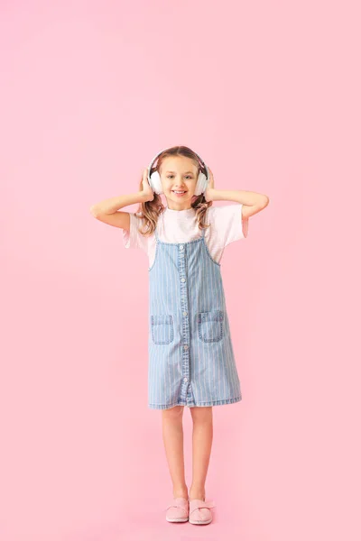 Cute little girl with headphones on color background — Stock Photo, Image