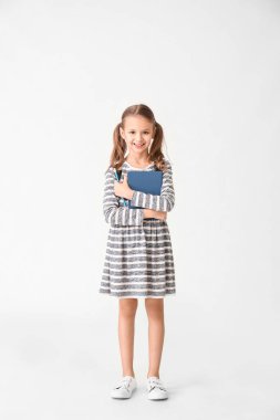 Beyaz arka plan kitabı olan sevimli küçük kız.