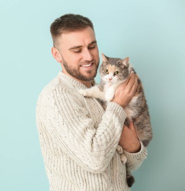 Renkli arka planda sevimli kedisi olan adam