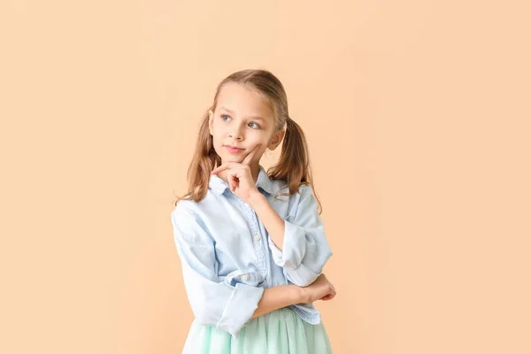 Thoughtful little girl on color background — Stock Photo, Image