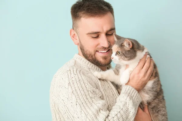 Man with cute cat on color background