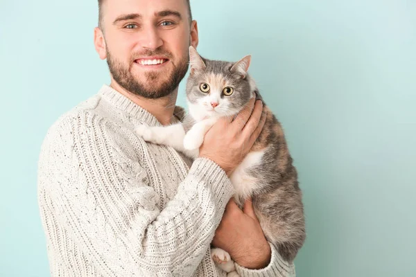 Uomo con gatto carino su sfondo di colore — Foto Stock