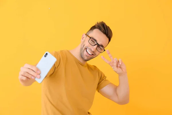 Handsome man taking selfie on color background — Stock Photo, Image