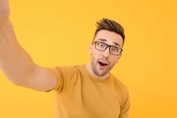 Handsome man taking selfie on color background — Stock Photo, Image