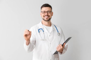 Erkek kardiyolog ışık arkaplanına karşı sanal ekranda yazıyor