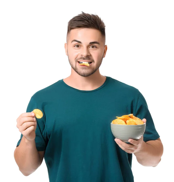 Handsome young man eating tasty potato chips on white background — Stock Photo, Image