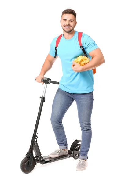 Handsome male student with tasty potato chips and kick scooter on white background — 스톡 사진