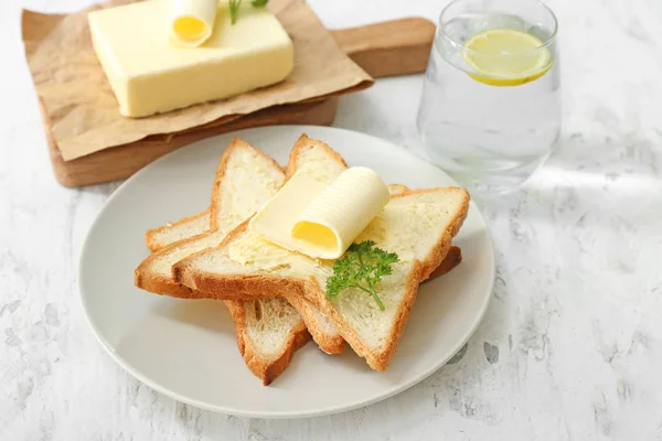 Plate with slices of bread and fresh butter on white background — Stock Photo, Image