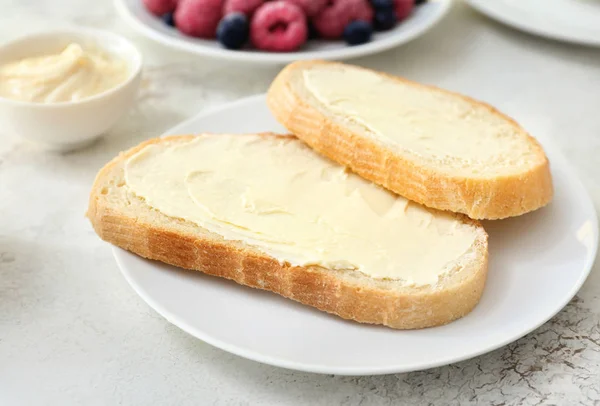 Teller mit Brotscheiben und frischer Butter auf weißem Hintergrund — Stockfoto