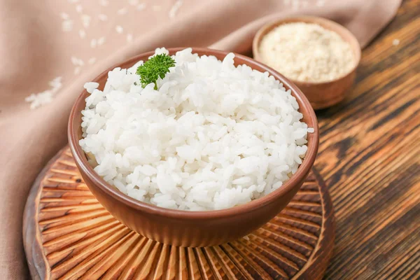 Vařenou rýži v misce na dřevěný stůl — Stock fotografie
