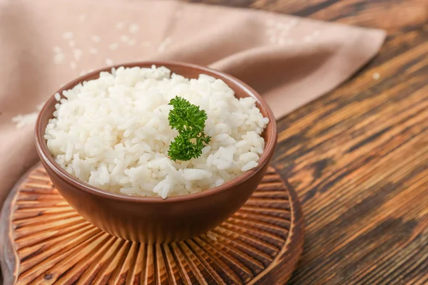 Boiled rice in bowl on wooden table — Stock Photo, Image