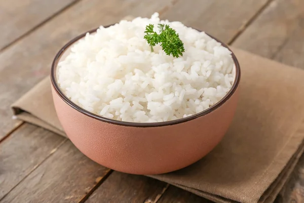 Ahşap masa üzerinde kase haşlanmış pirinç — Stok fotoğraf