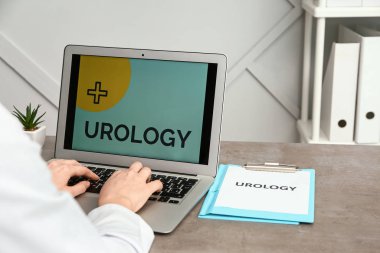 Masada dizüstü bilgisayarda çalışan kadın ürolog.