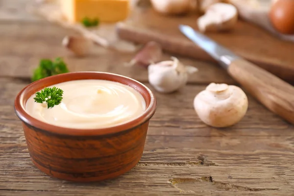 Bowl of tasty mushroom sauce on wooden table