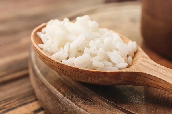 Spoon with boiled rice on wooden table, closeup — Stock Photo, Image