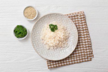 Beyaz ahşap zemin üzerinde haşlanmış pirinç tabağı.