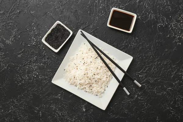 Bord met gekookte rijst en sojasaus op donkere ondergrond — Stockfoto