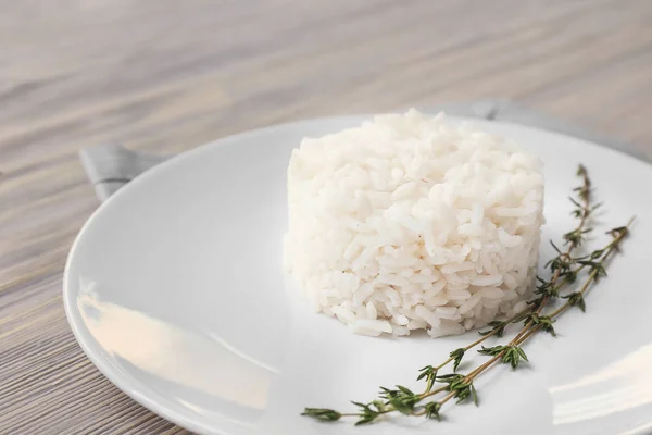 Płyta z gotowanym ryżem na białym drewnianym tle — Zdjęcie stockowe