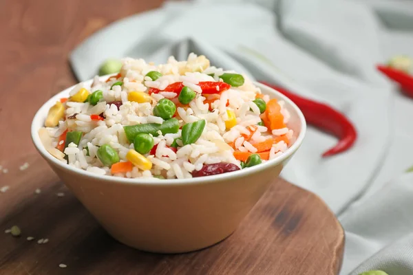 Tigela com arroz fervido e legumes na mesa — Fotografia de Stock