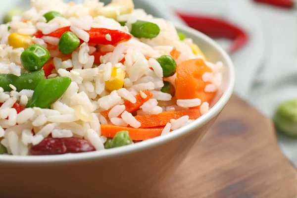 Tigela com arroz fervido e legumes na mesa, close-up — Fotografia de Stock