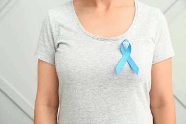 Gri arka planda mavi kurdeleli bir kadın. Prostat kanseri farkındalığı