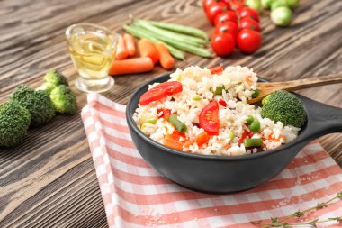 Ahşap masada tavada sebzeli haşlanmış pirinç.