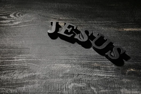 Word JESUS on dark wooden background — Stock Photo, Image