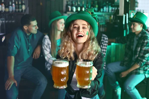 Jonge vrouw met bier viert St. Patrick 's Day in pub — Stockfoto