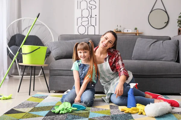 Joven ama de casa y su hijita limpiando su piso — Foto de Stock