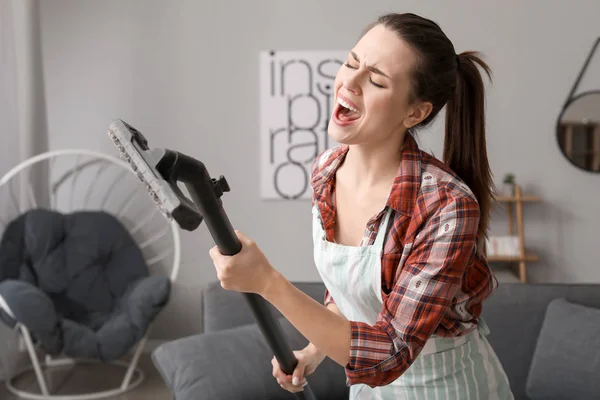 Jong huisvrouw zingen terwijl het schoonmaken van haar flat — Stockfoto