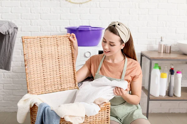 Linda jovem dona de casa com lavanderia em casa — Fotografia de Stock