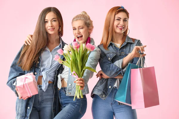 Mooie jonge vrouwen met geschenken op kleur achtergrond. Internationale Vrouwendag viering — Stockfoto